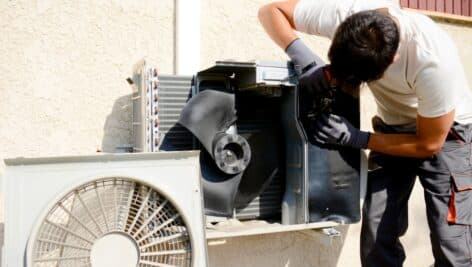 hvac technician repairing a compressor.