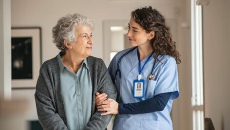 A Widener nursing student helps an older patient.