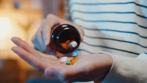 woman holding handful of pills