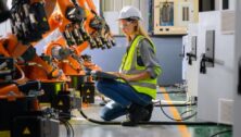 female worker checking robotic machine