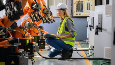 female worker checking robotic machine