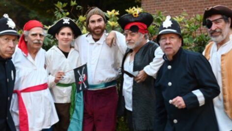 Sergeant of Police, Steve Zimmerman, is overrun by pirates Steve Nazigian, Fiona Tillman, Tim Tillman, Pirate King Ray Murphy, the sergeant’s equally bewildered policeman, Robert Moore, and Don Cheetham, in a production of The Pirates of Penzance by the Rose Valley Chorus and Orchestra.