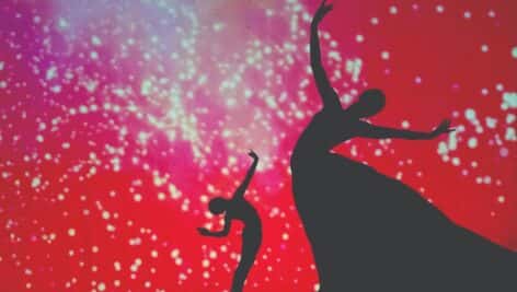 Silhouettes dancing against a red backdrop.