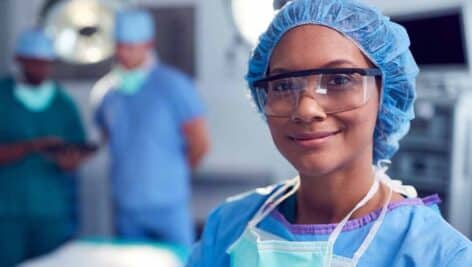 A WilmU nurse in the anesthesiology program dressed in scrubs/cap in hospital setting.