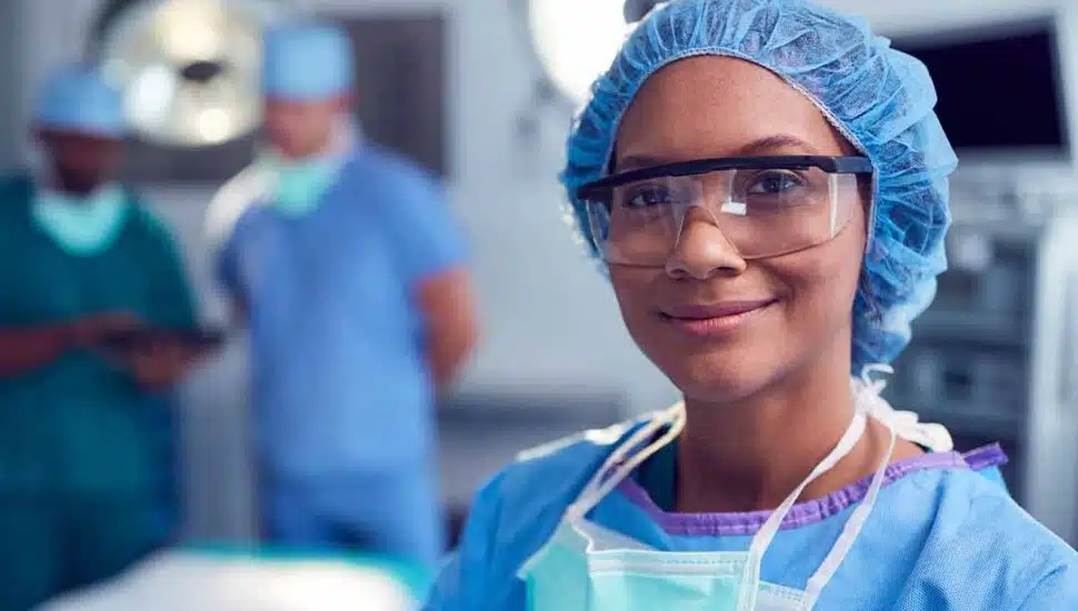 A WilmU nurse in the anesthesiology program dressed in scrubs/cap in hospital setting.