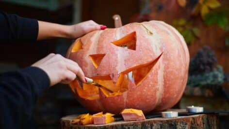 person carving pumpkin