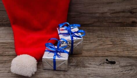 A Santa cap next to some small wrapped gifts.