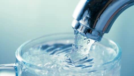 close-up view of water flowing from tap into glass