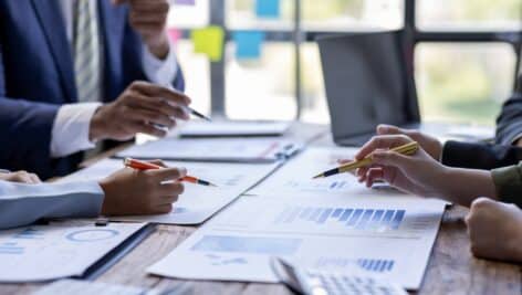 people sitting at table with papers