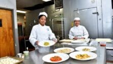 DCCC Culinary Arts students in kitchen with prepared dishes.