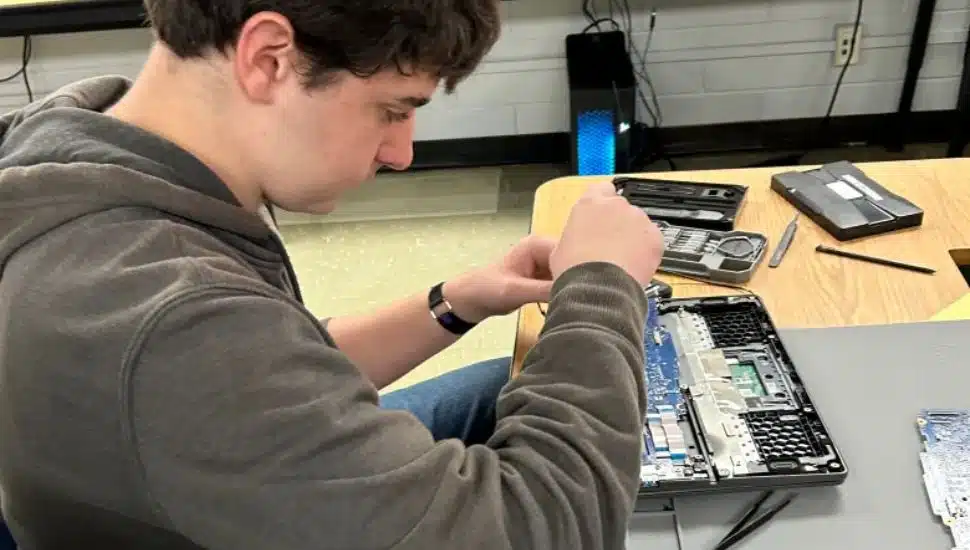 Student Dom Spoto fixes a Chromebook for the help desk.