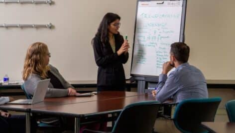 Penn State Great Valley graduate students discussing topics around a table.