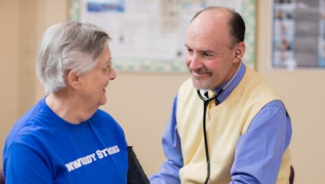 A doctor talks with a Dunwoody Village resident wearing a “Dunwoody Strong” shirt.