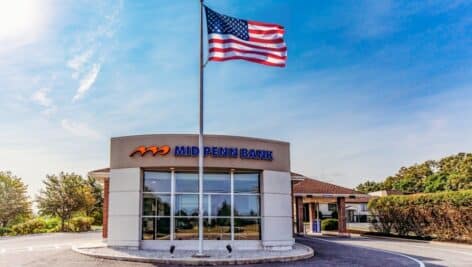 Bank building exterior with American flag.