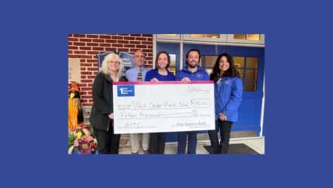 First Resource Bank team members presenting a check to a local school.