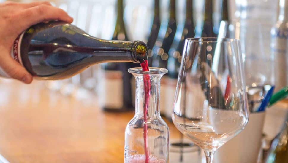 man pouring wine into a decanter