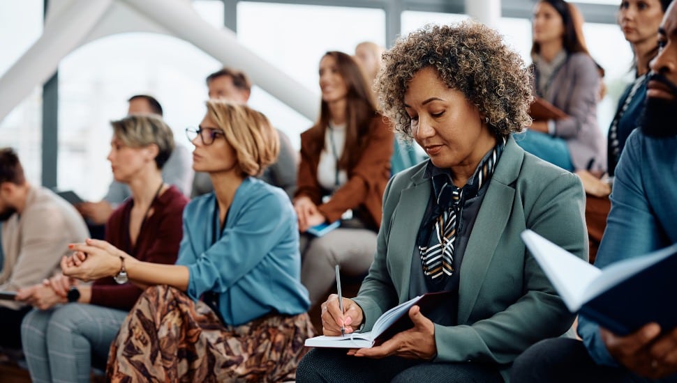 A woman taking notes at a group class.