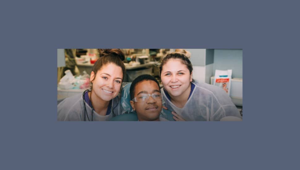 Harcum dental students with a young patient.