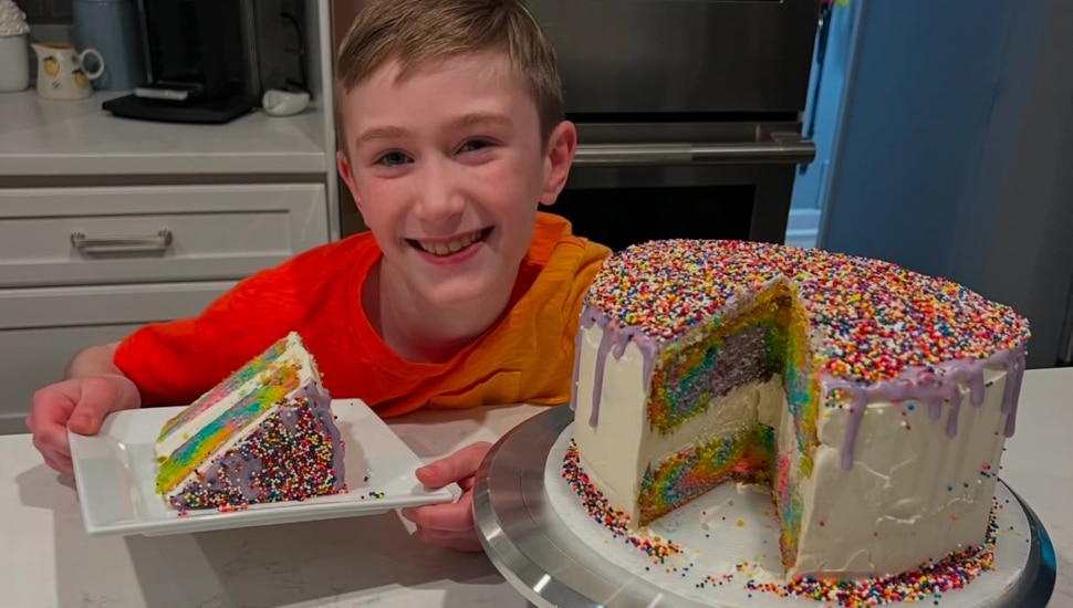 Carter Siporin holding rainbow piece of cake.