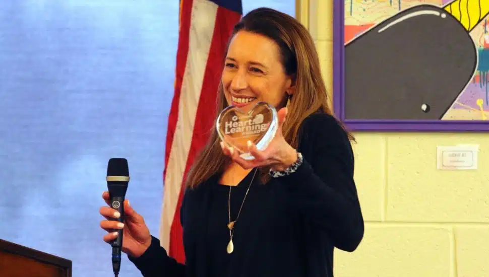 Teacher accepts excellence award.