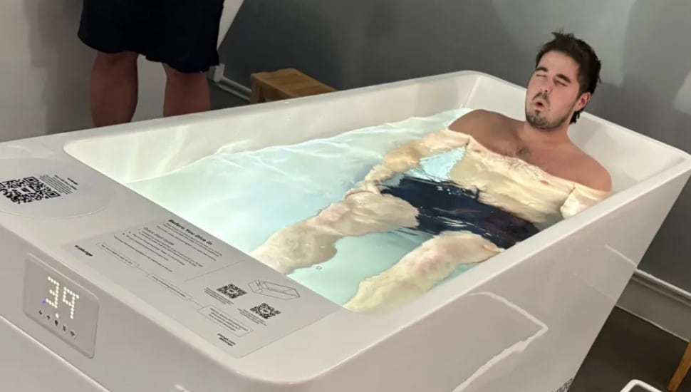 Man doing cold plunge in tub.