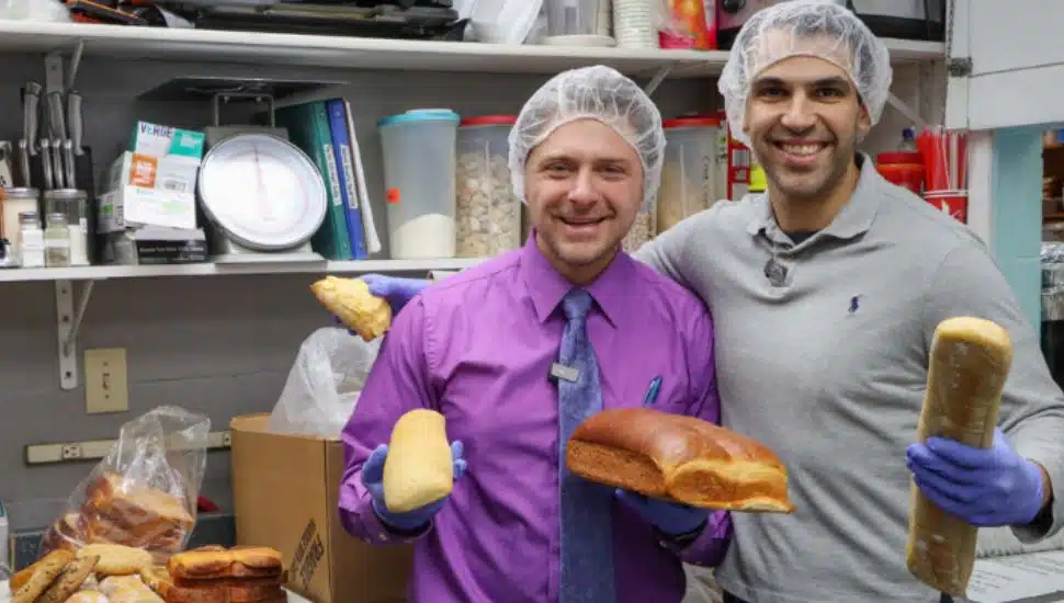 Derek Fiorenza and Jason Litman holding bread and and wearing hair nets.