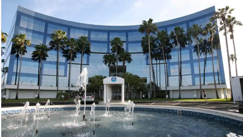HSN HQ with fountain and large building with glass windows.