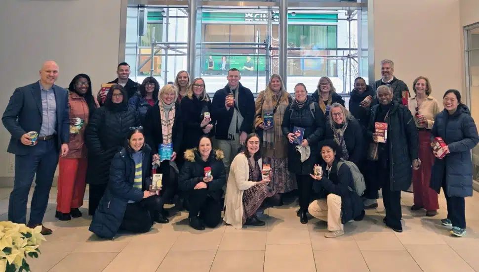 Group photo of company employees with food donations.