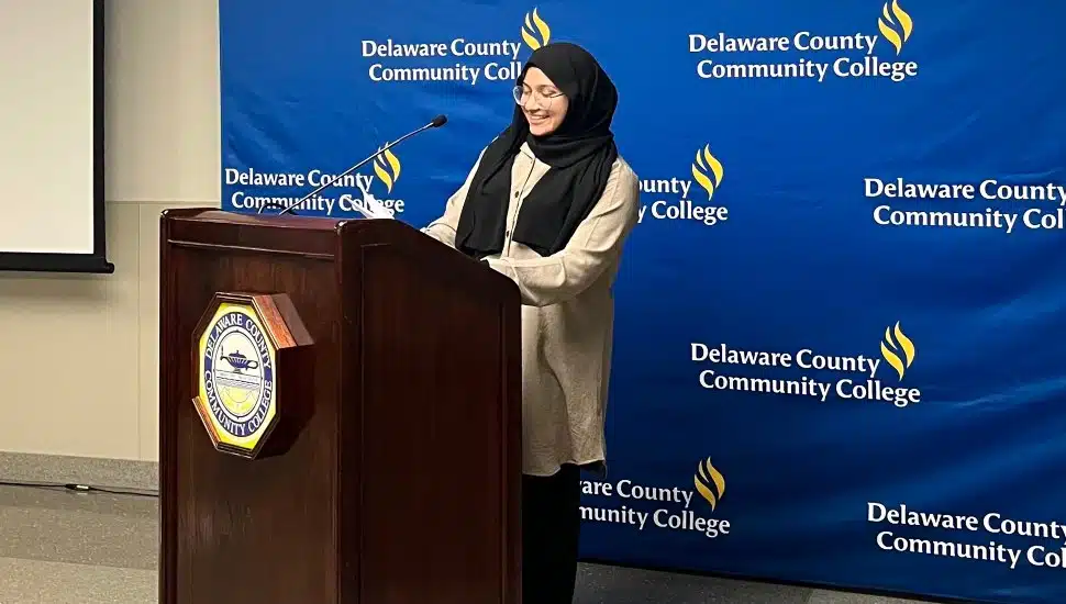 Delaware County Community College student Needah-e-fatema Hafeezali Gangji, pictured behind a podium, was named a 2024 Coca-Cola Leaders of Promise Scholar.