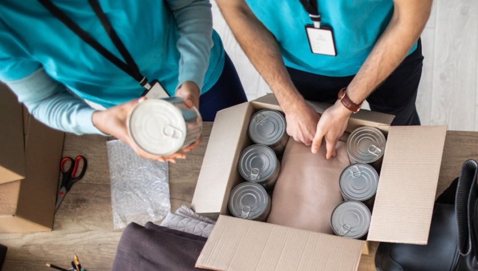 Two people pack canned goods for emergency relief.