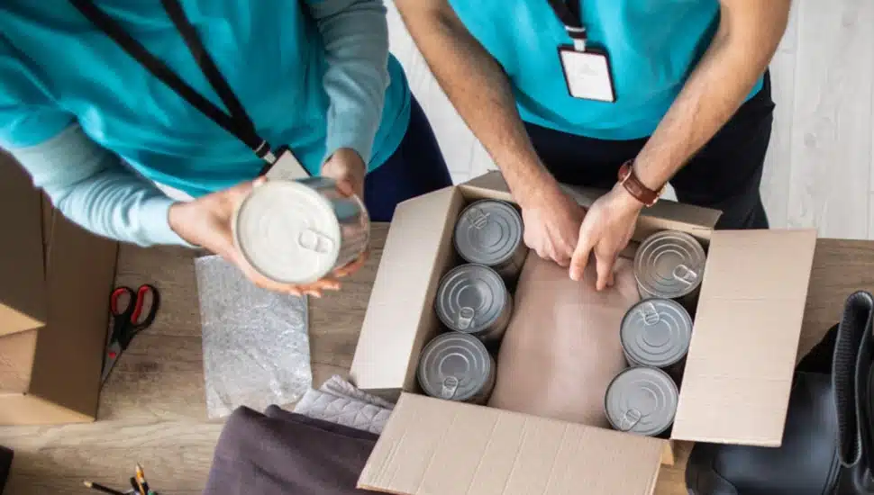 Two people pack canned goods for emergency relief.