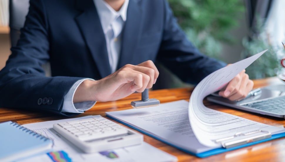 Businessman works on his taxes at a desk.