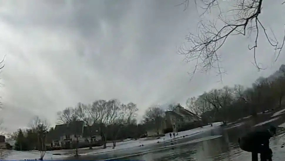 Body cam image of police rescuing dogs on ice.