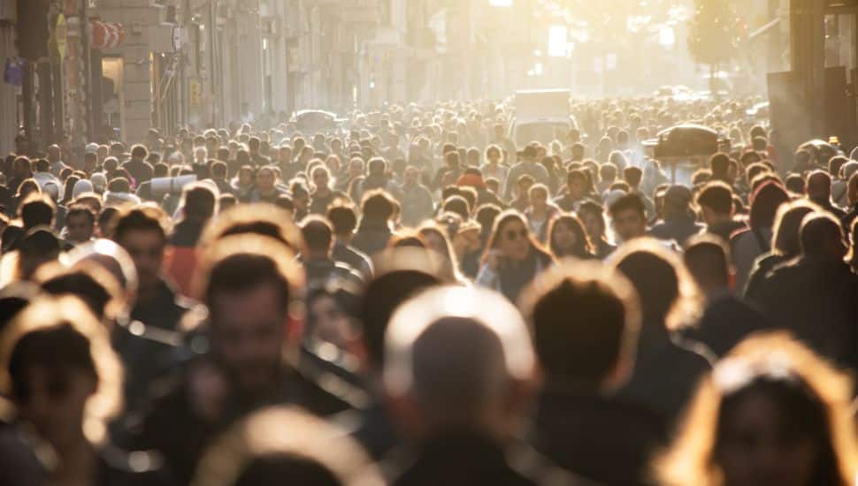 Hundreds of people walking together in a crowd.