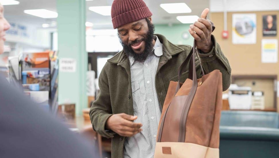 Man holding leather purse from Atelier 56.