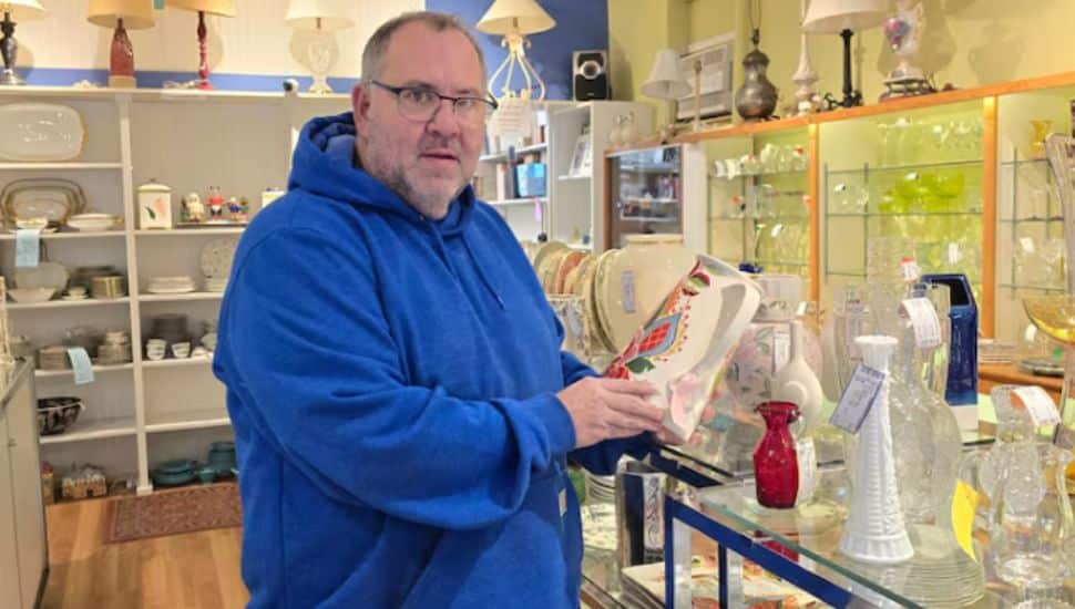 John Romani in blue sweatshirt standing in a store.