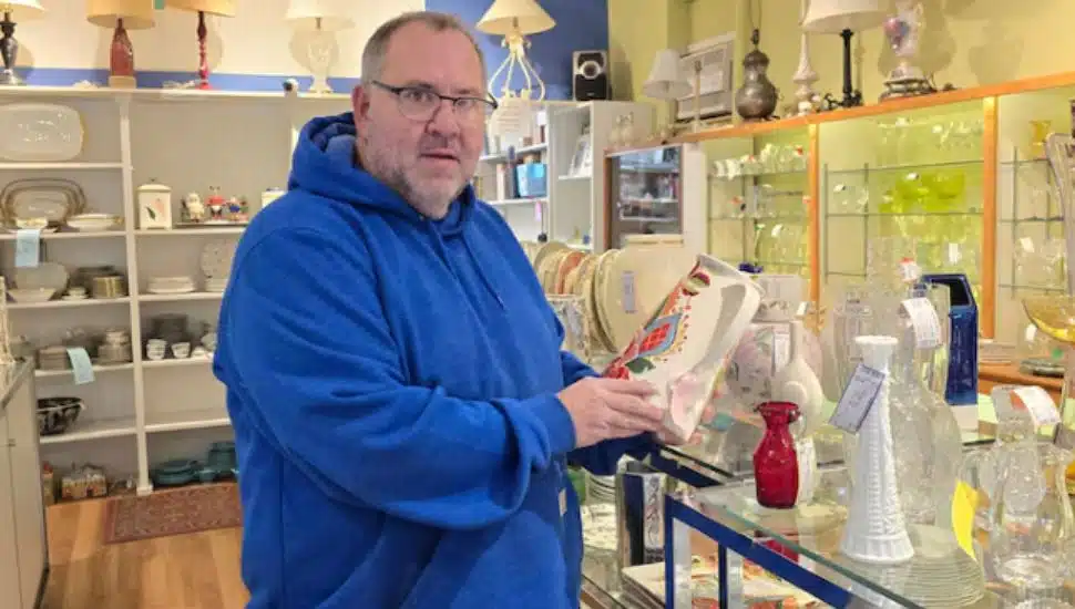 John Romani in blue sweatshirt standing in a store.