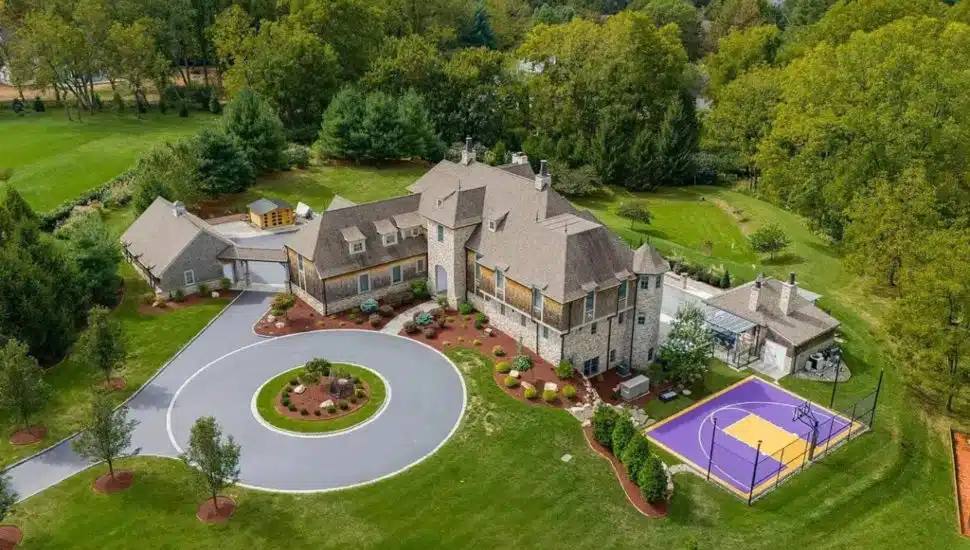 Malvern mansion aerial view with basketball court and big driveway.