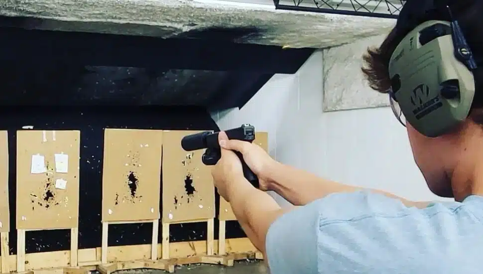 Man shooting a gun at a range.