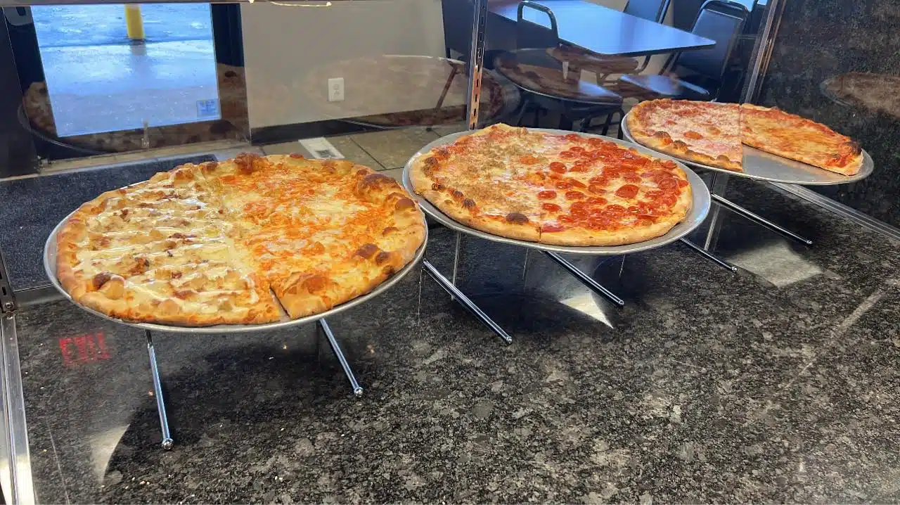 Three pizzas on trays.