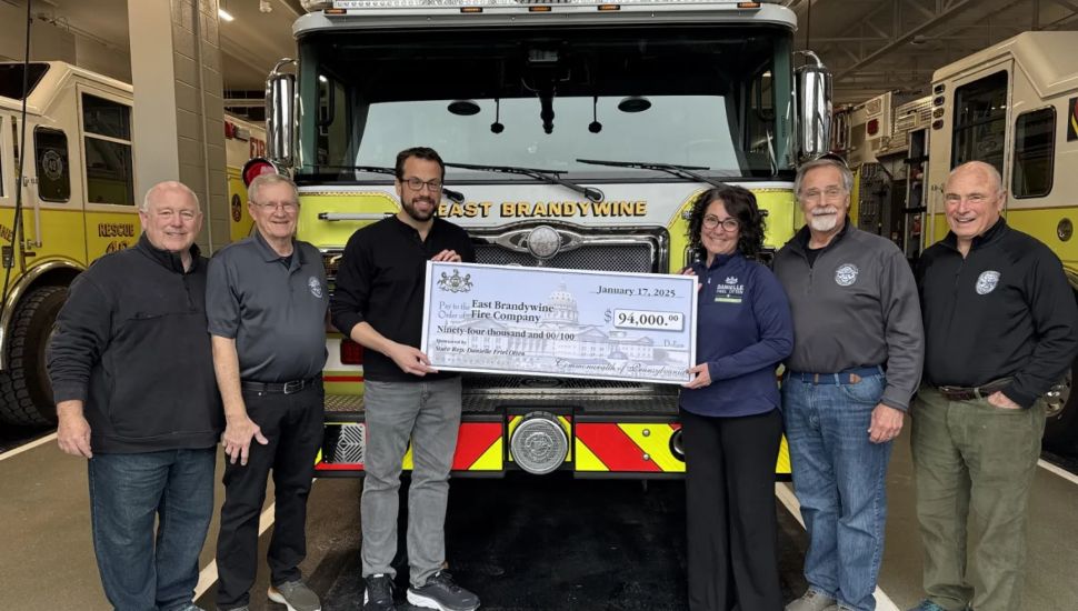 Firefighters with big check at station.
