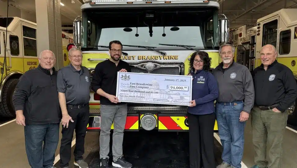 Firefighters with big check at station.