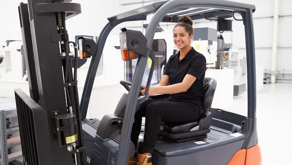 Portrait Of Female Fork Lift Truck Driver In Factory.
