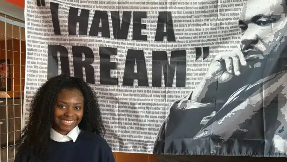 Student Kyia Smith with MLK tapestry behind her.