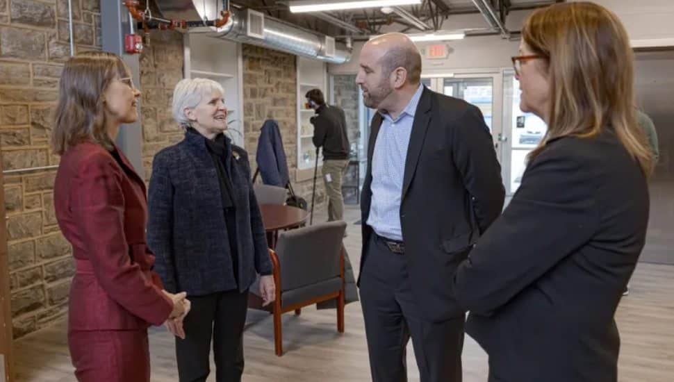 Four people standing and talking to each other.