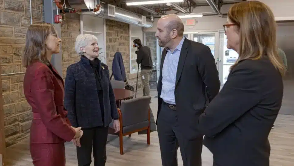 Four people standing and talking to each other.