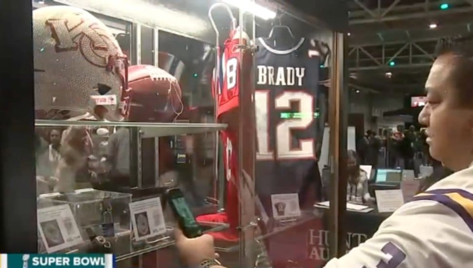 Person views football memorabilia on auction.