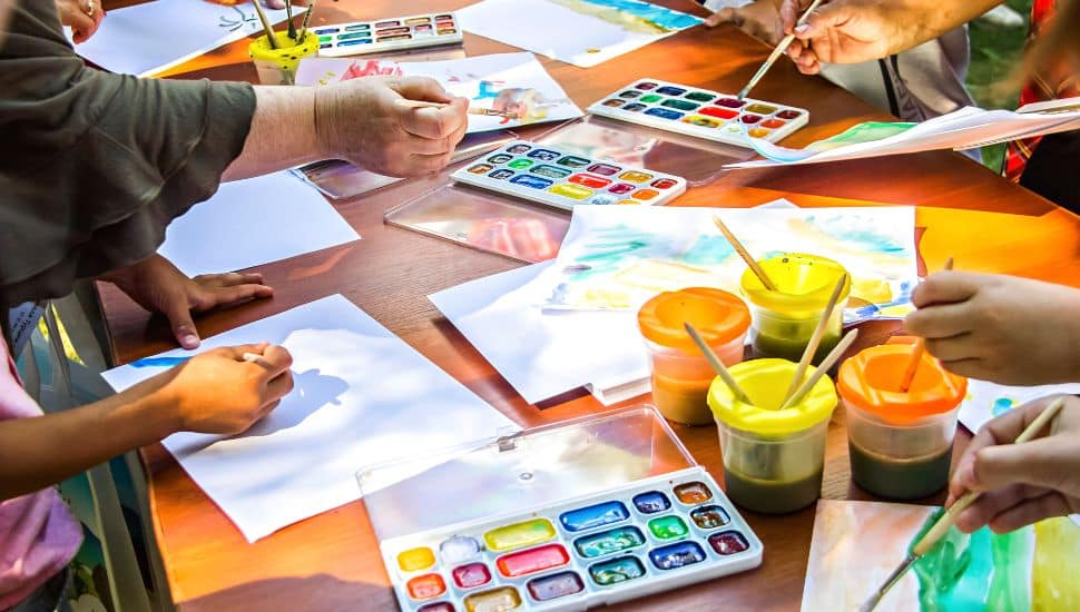 Adults and kids doing a watercolor workshop.
