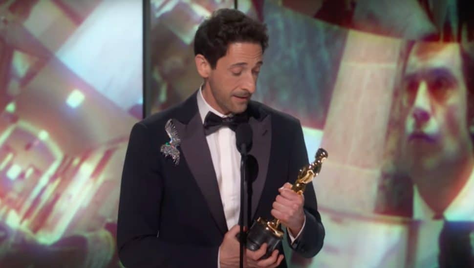 Adrien Brody on stage with Oscar award.