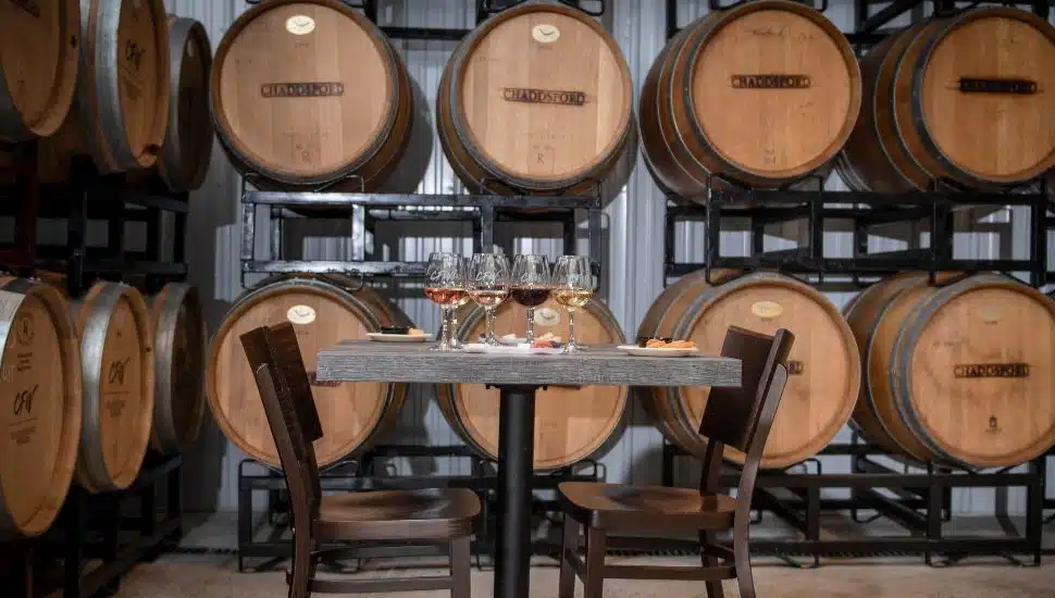Table and chairs surrounded by wine barrels at Chaddsford Winery.